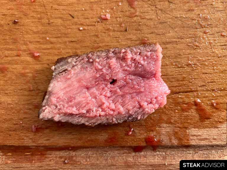 A slice of strip steak, freshly salted just before cooking and perfectly cooked to a medium-rare