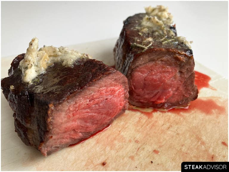 Broiled steak sliced and topped with compound butter