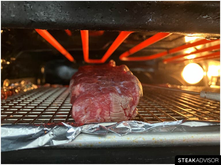 Steak broiling in the oven under high heat