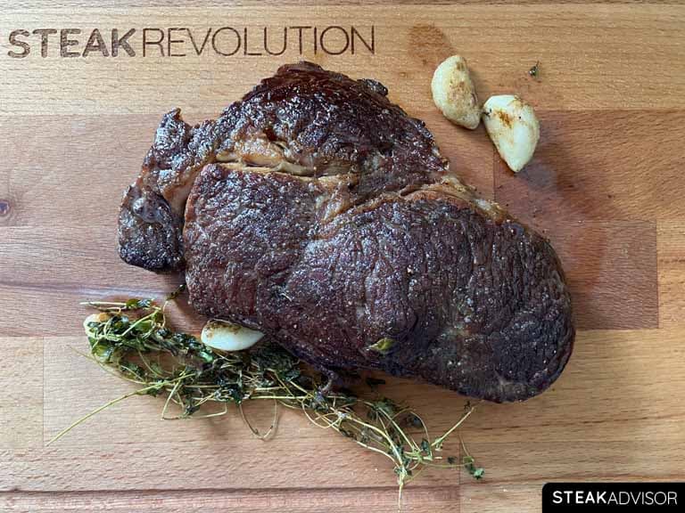 Cast iron seared steak on a wooden cutting board