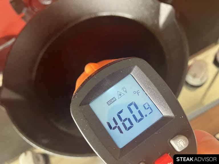 Cast-iron skillet with an infrared thermometer displaying 460°F.