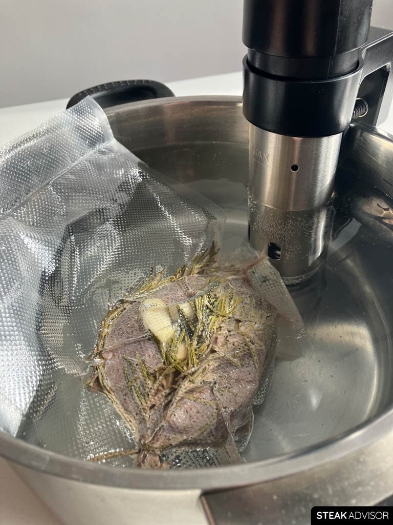 A steak cooking sous vide in a temperature-controlled water bath for precise doneness.