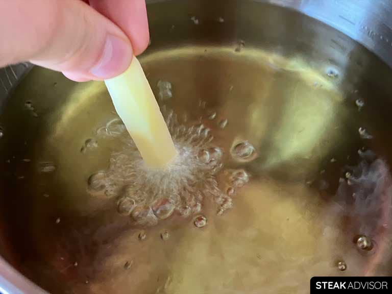 Fizzling bubbles as fries are immersed in hot oil