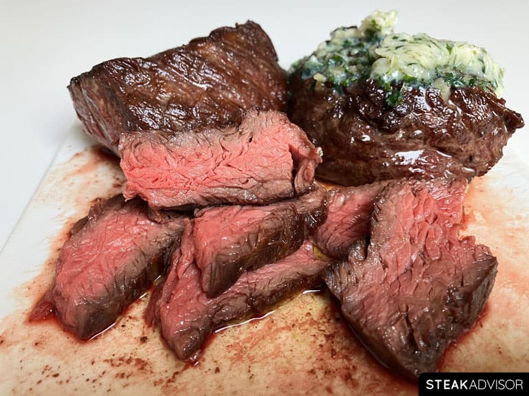 Juicy medium-rare hanger steak slices cut against the grain and topped with melted garlic herb butter.