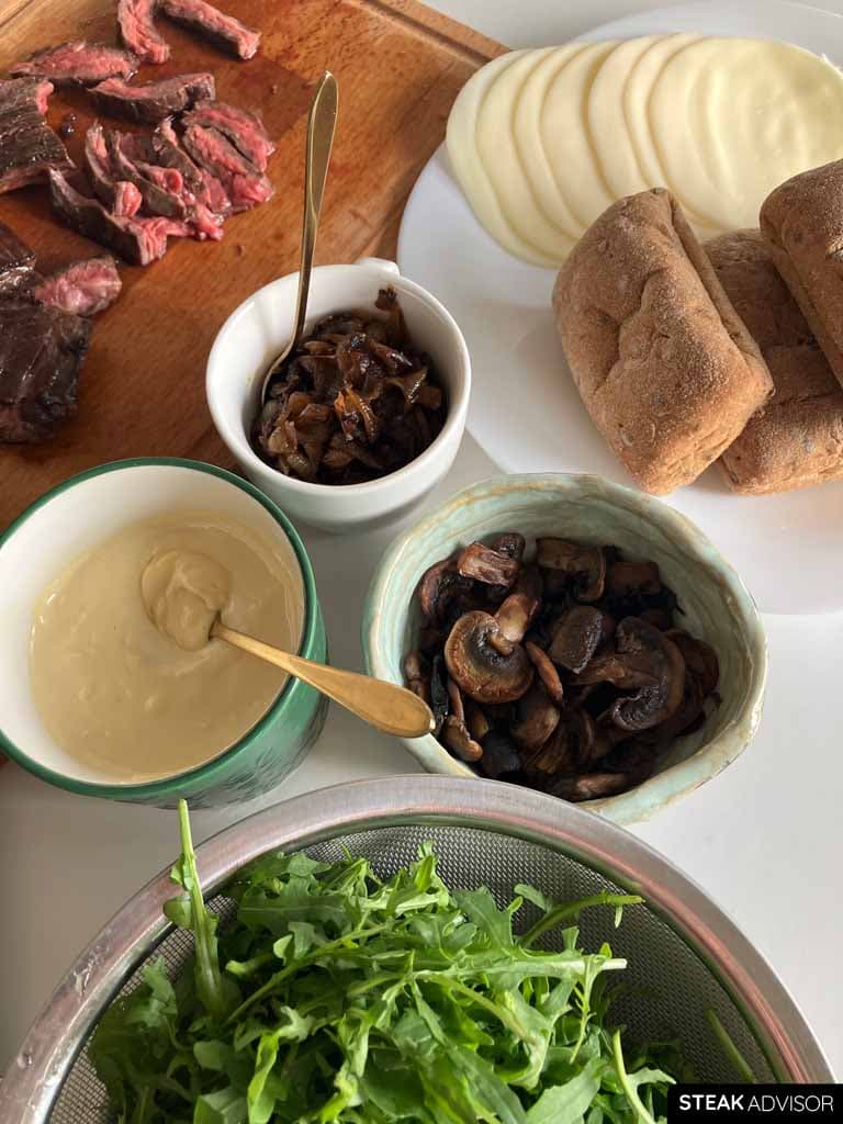 Seared and sliced skirt steak, ciabatta rolls, caramelized onions, aioli sauce, provolone cheese, sauteed mushrooms, and fresh arugula.