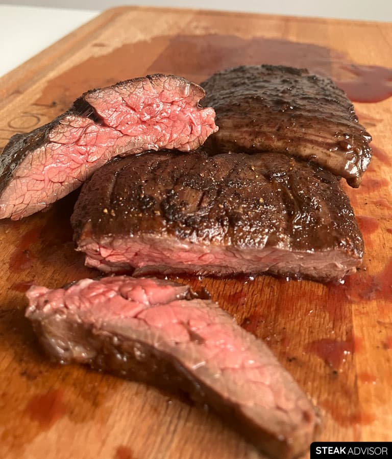 Pan seared skirt steak sliced and served on a wooden cutting board