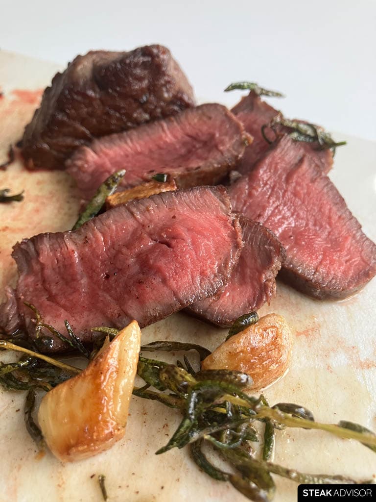 Pan seared filet mignon sliced and served with garlic-herb butter mixture.