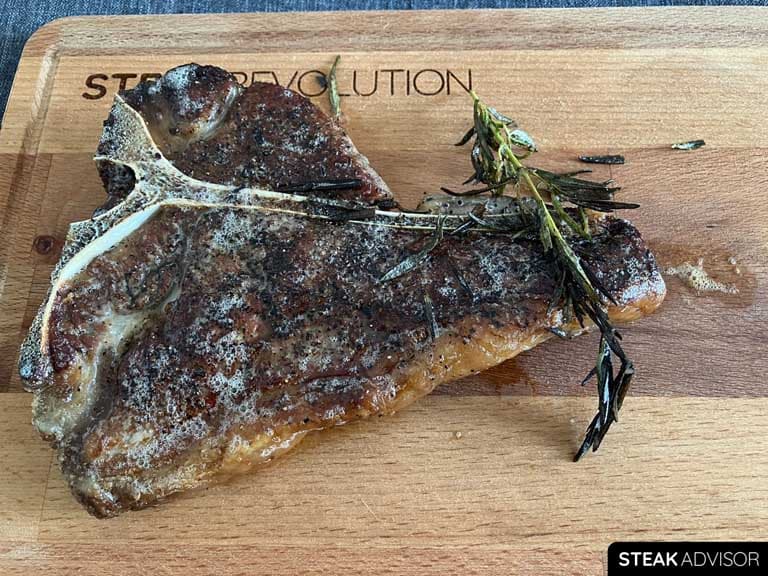 Porterhouse steak cooked with garlic, rosemary, and butter in a cast iron skillet