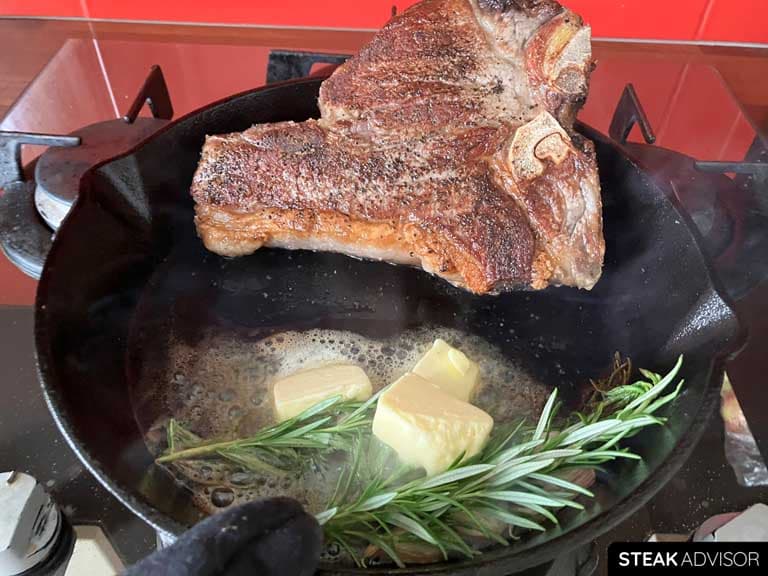 Porterhouse steak, seared in a cast iron skillet with butter, rosemary, and garlic.