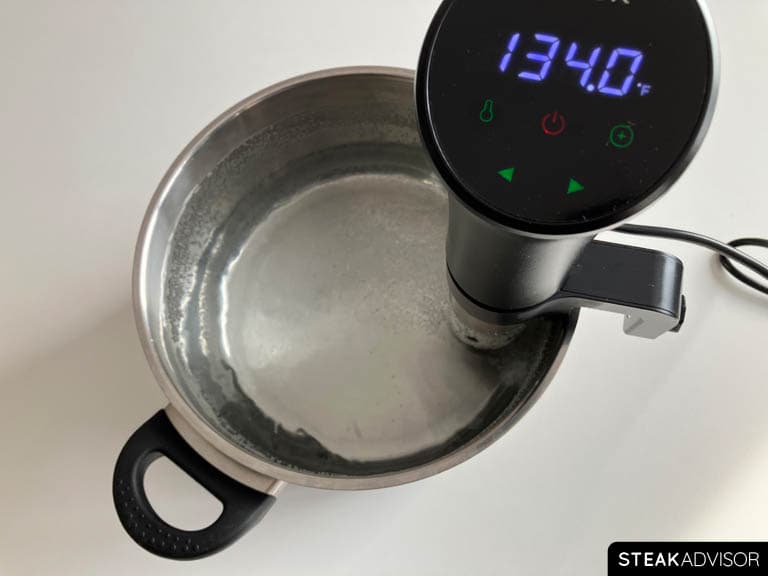 Preparing the sous vide cooker and water bath for precise steak cooking.