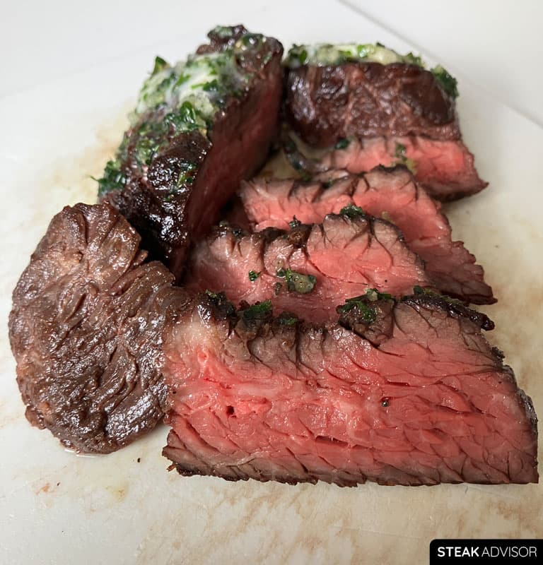 Juicy medium-rare hanger steak slices cut against the grain and topped with melted garlic herb butter.