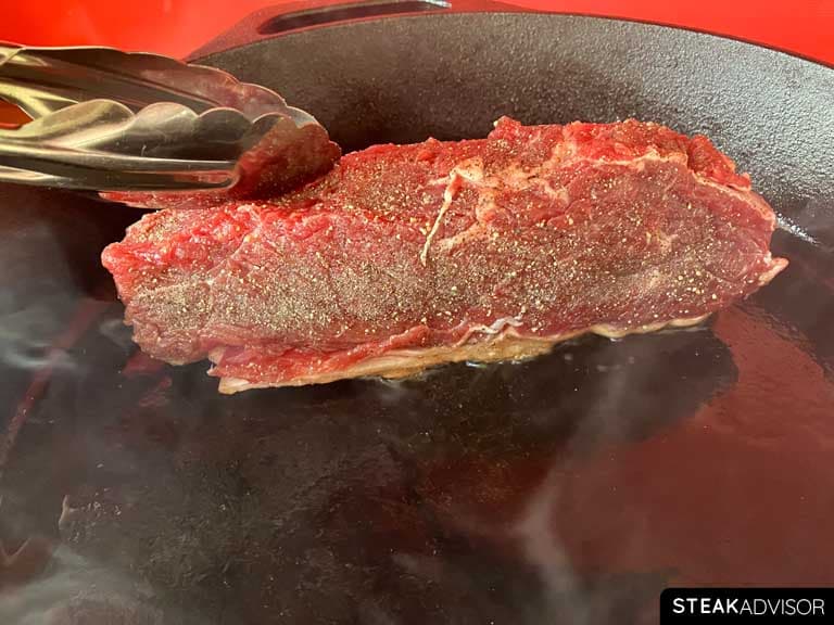 Steak seared fat side down in a hot pan