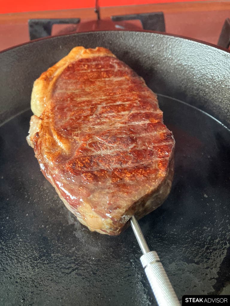 Steak being seared to develop a golden-brown crust