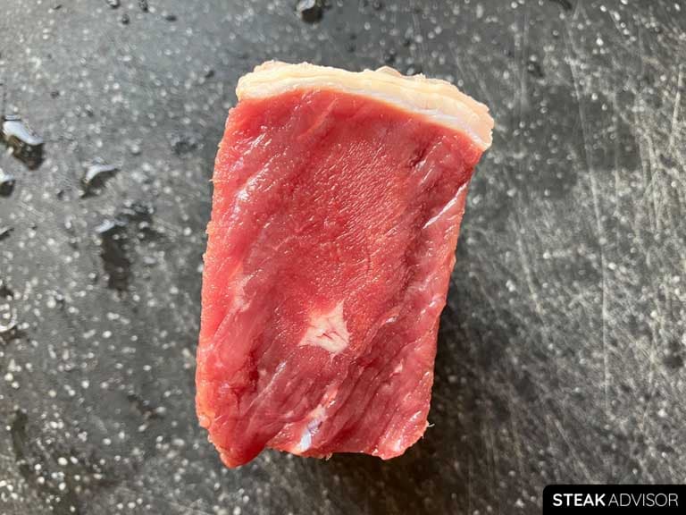 1.75-inch (4.4 cm) thick strip steak thawed using the cold running water method for 45 minutes. Unfortunately, the center is still frozen.