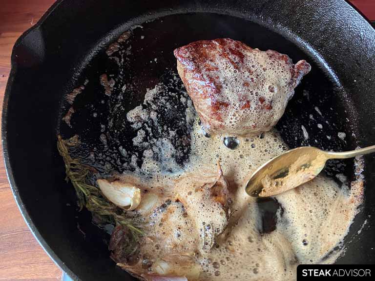 Baste the flat iron steak with the melted butter