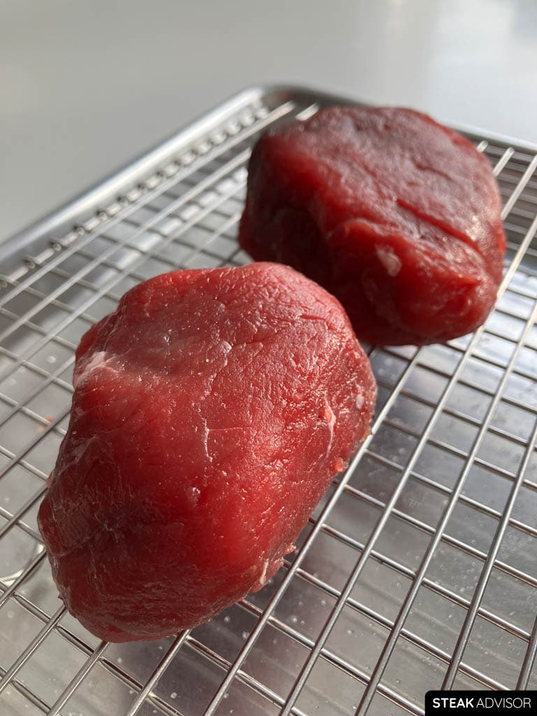 Dry-brined filet mignon resting on a rack, ready to cook