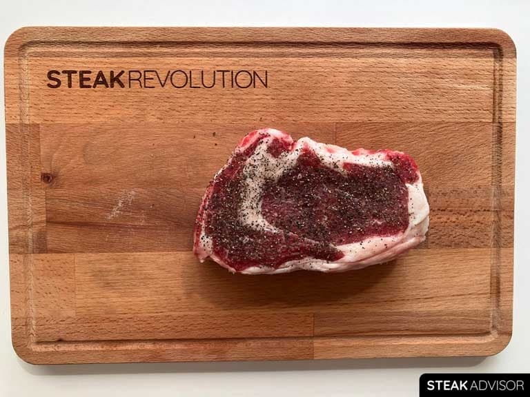 Ribeye steak seasoned with ground black pepper