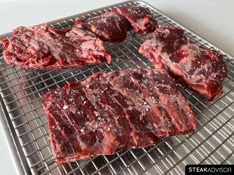 Raw skirt steaks seasoned with kosher salt